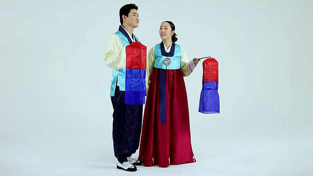 韩国首尔，一对身穿韩服的夫妇提着传统灯笼走在街上视频素材