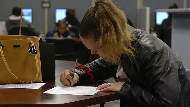 MS手的妇女填写表格在州经营的就业中心/杰克逊，密歇根州，美国视频下载
