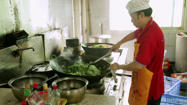 ZI女士在大型工作中烹饪蔬菜/中国广东深圳视频素材