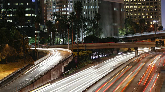 美国加利福尼亚州洛杉矶市市中心威尔特郡的菲格罗亚，延时高速公路灯光在晚上的踪迹视频素材