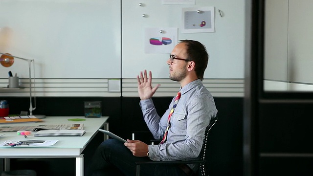 MS DS的商人坐在办公室里讨论数字平板电脑/西雅图，华盛顿，美国视频素材