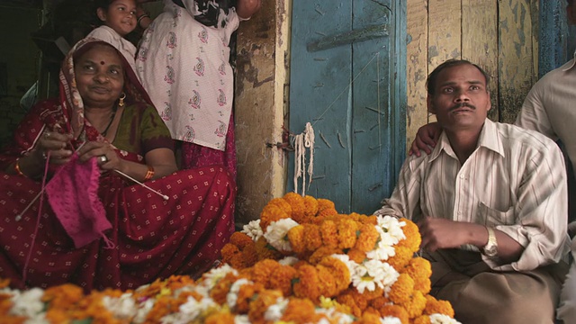 WS女人在花小贩摊位编织/德里，印度德里视频下载
