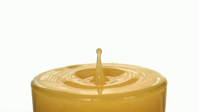 CU SLO MO在白色背景下一滴橙汁落入玻璃杯/ Vieux Pont，诺曼底，法国视频下载