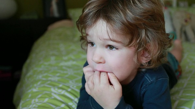 CU TD小男孩趴在床上，手臂和手指含在嘴里/加拿大安大略省多伦多视频素材