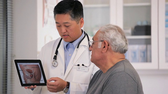 MS PAN医生在平板电脑上向老年患者展示前列腺图/ Richmond, Virginia, USA视频购买