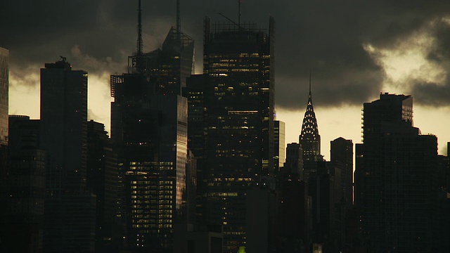 克莱斯勒大厦和邻近的建筑物在黄昏的曼哈顿天际线与云移动在黑暗的天空视频素材