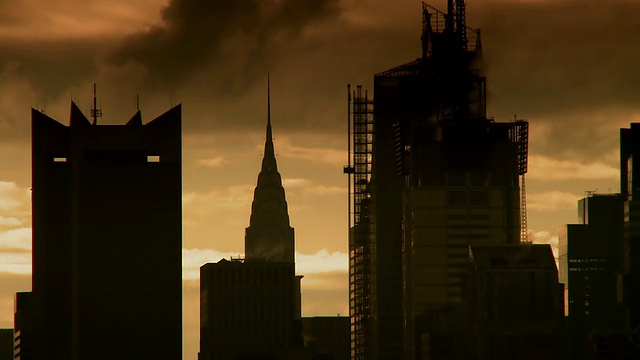 蒸汽在纽约市清晨的天空中升起，掠过克莱斯勒大厦、美国银行大厦和邻近的摩天大楼的剪影视频素材