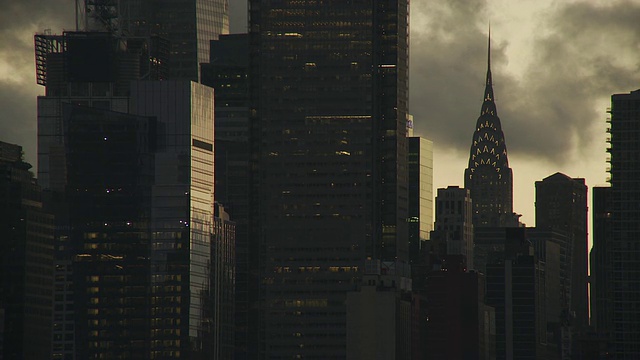 黄昏时分，当云朵在空中移动时，克莱斯勒大厦和邻近的摩天大楼出现在纽约市的天际线上视频素材