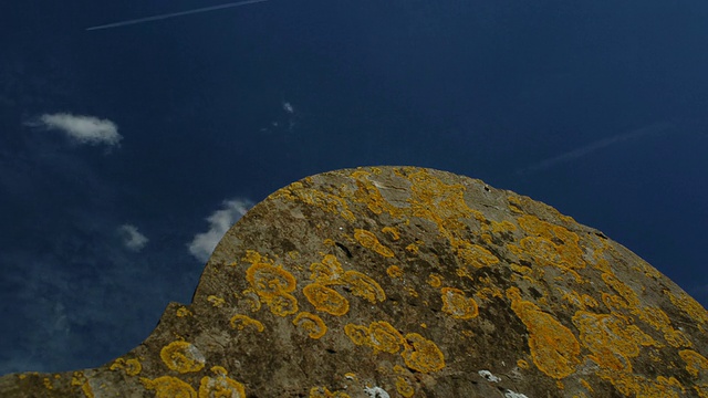 T/L卷云和蒸汽轨迹掠过苔藓覆盖的墓碑，英国视频下载