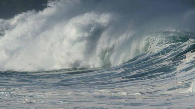 泡沫状的海浪拍打着海岸房屋附近的黑色岩石视频下载