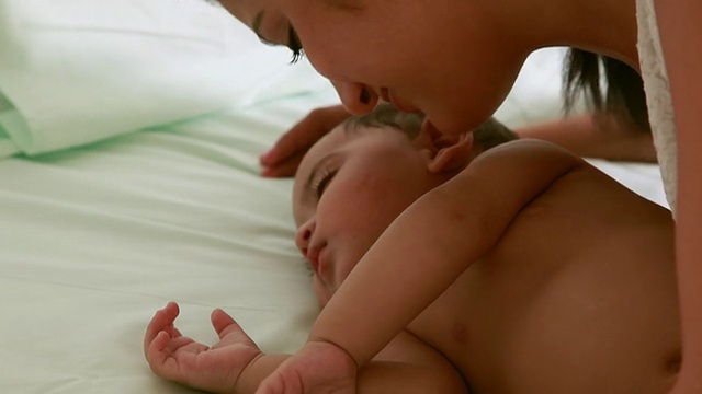 女人亲吻熟睡的婴儿视频素材