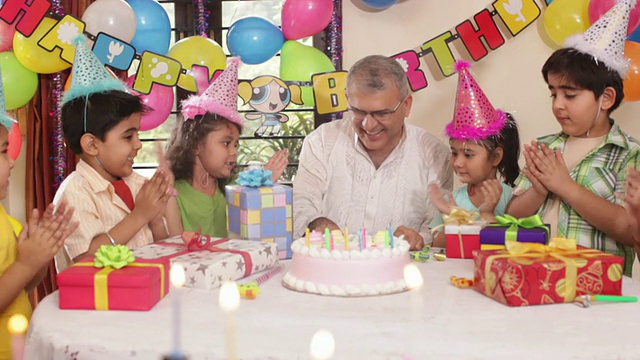 一位老人正在和他的孙辈们庆祝生日视频素材