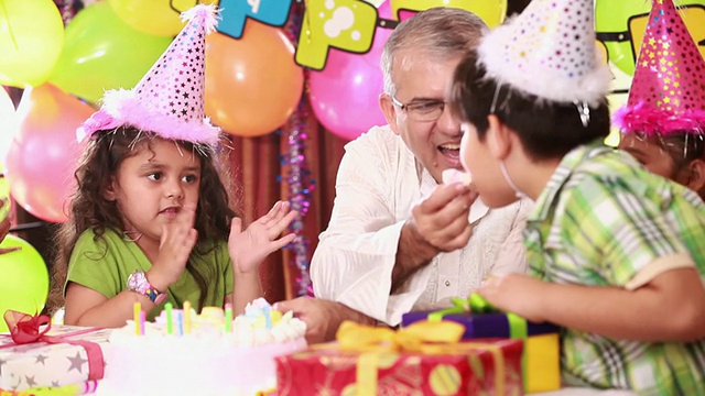 一位老人正在和他的孙辈们庆祝生日视频素材