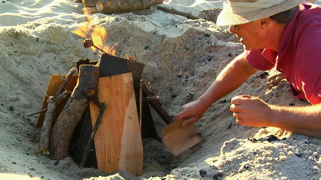 在美国马萨诸塞州北特鲁罗海滩，一名男子正在准备篝火视频素材