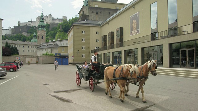 在节日大厅的主入口前是一辆WS马车，背景是霍亨萨尔茨堡城堡视频素材