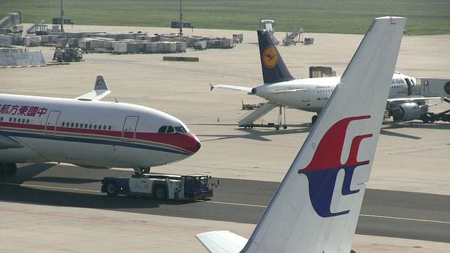 德国黑塞法兰克福机场，拉动飞机和两架停着的飞机视频素材