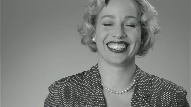 B/W MS肖像女人红色圆点连衣裙/ ZI CU女人把手放在脸上给予惊讶的表情和大笑/纽约视频下载
