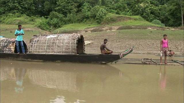 中等射击-船漂过人站在另一船/孟加拉国视频素材