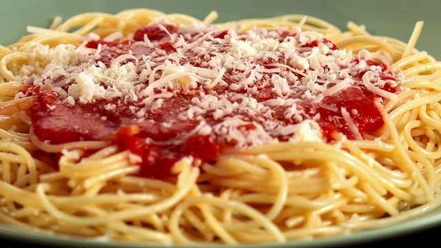 美国加州洛杉矶，将帕尔马干酪洒在旋转的意大利面上，上面淋上番茄酱视频下载