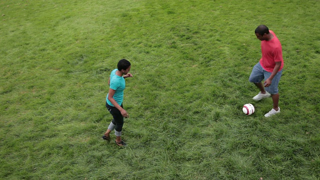 女人和男人在草坪上踢足球/波特兰，俄勒冈，美国视频素材