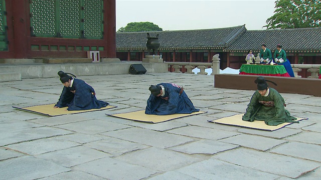 韩国首尔庆福宫举行的朝鲜王朝复兴活动中，身着传统制服的人们鞠躬致敬视频素材