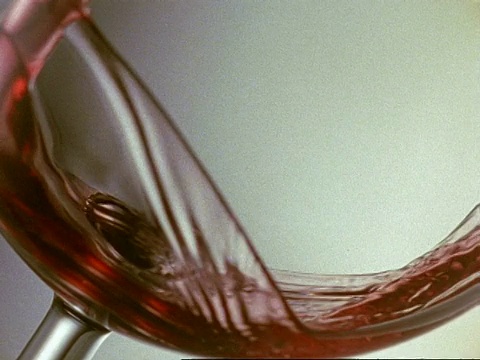 高速BCU红酒倒入一个倾斜的玻璃杯底部，白色背景，填充镜头视频素材