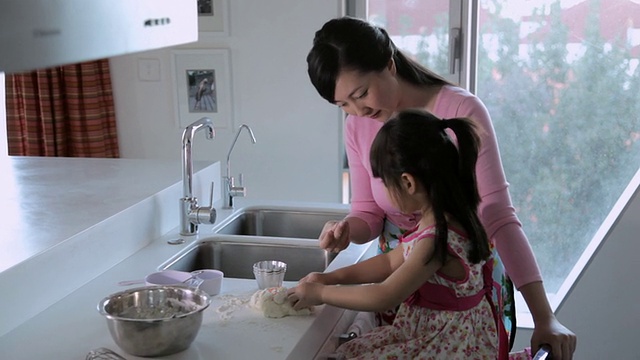 TU女士母女在厨房里一起做饭视频素材