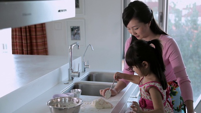 MS Mother and daughter making food together in kitchen / China视频素材