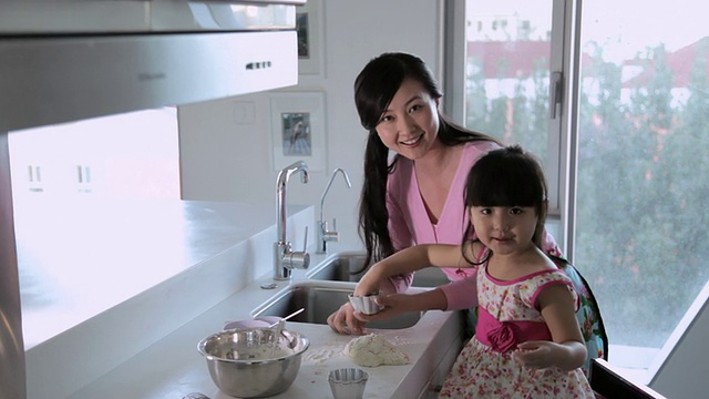 母亲和女儿一起在厨房准备食物/中国视频素材