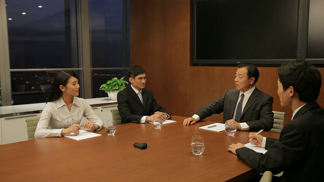 DS MS资深商务人士在会议室/中国与年轻商务人士交谈视频素材