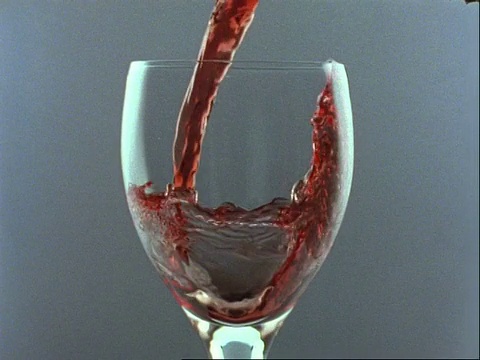 高速铜红葡萄酒倒入玻璃，灰色背景视频素材