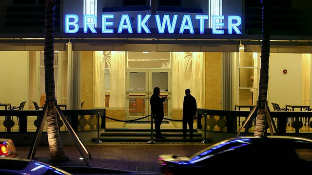 美国佛罗里达州迈阿密，晚上，汽车和行人在酒店前经过视频素材