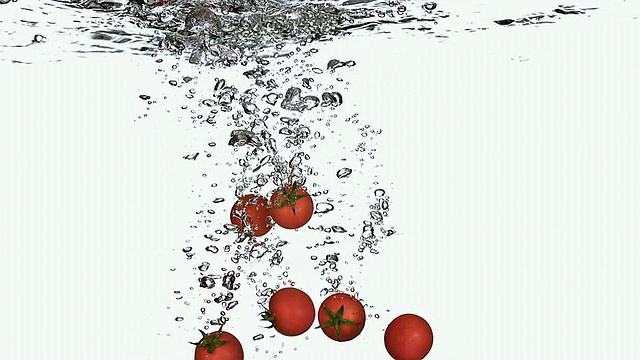 MS SLO MO樱桃番茄进入水中的白色背景/ Vieux Pont，诺曼底，法国视频素材