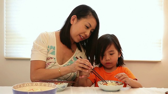 母亲教儿子如何使用筷子/美国加州洛杉矶视频素材