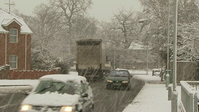 在英国，人们过马路和汽车在大雪中视频素材