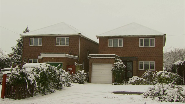 MS pan正好穿过一排被雪覆盖的郊区房屋，英国视频素材