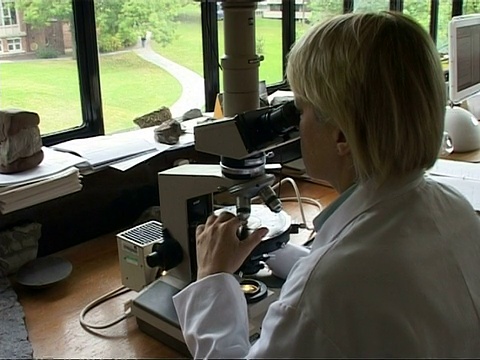 科学家向下看显微镜，旋转物镜，旋转舞台，放大到CU视频下载