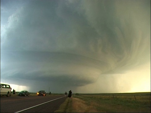 美国，在路边停着的汽车和追逐风暴的人注视下，从巨大的超级风暴/雷云中闪过的闪电视频下载