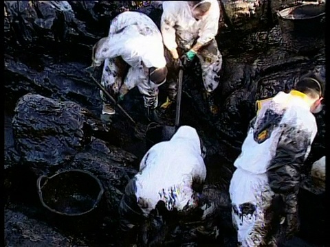 2002年，声望油轮漏油:清理队从西班牙西北海岸的岩石上刮油。视频下载