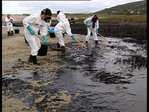 2002年，声望油轮漏油:清理队在西班牙西北海岸海滩上铲油。视频下载
