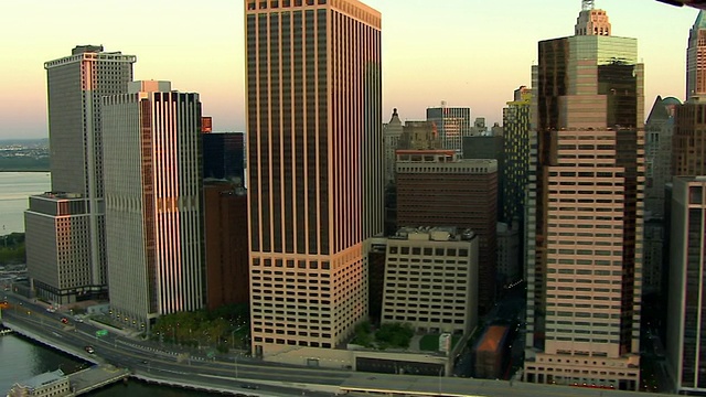 中远镜头空中跟踪左——布鲁克林大桥附近的东河上的摩天大楼。/纽约市视频素材