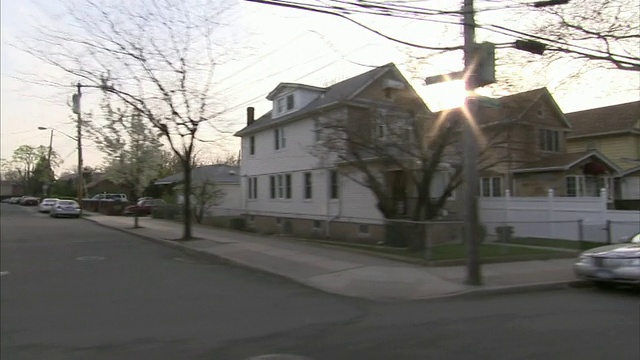 侧角手持式跟踪-在布朗克斯区附近的街道上，房屋排列成行。/美国纽约纽约市视频素材