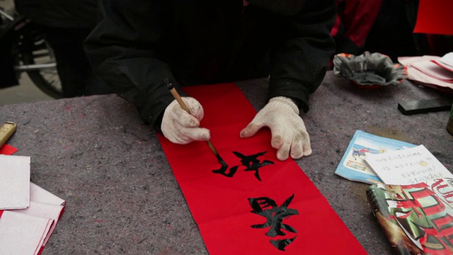 中国陕西西安，一个中国人在街道市场写春联视频素材