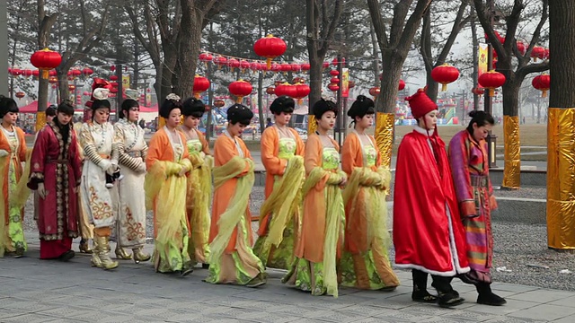 春节期间，中国陕西西安，女孩们装扮成古代伴娘在公园里散步视频下载