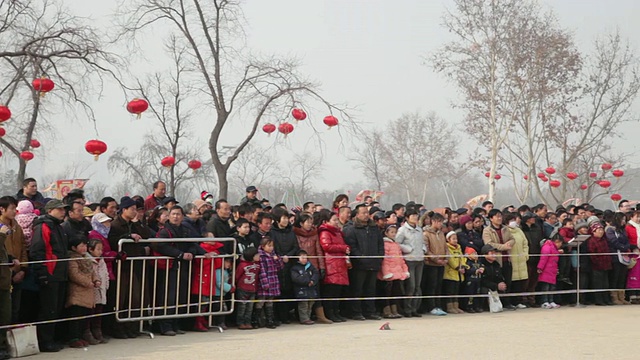 在中国陕西西安，人们围在庙会旁观看表演庆祝春节视频素材