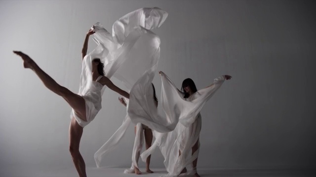 三个女舞者用丝织品裹着跳舞视频素材