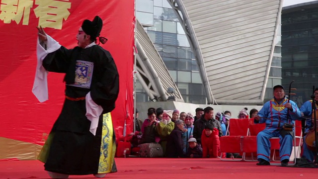 PAN TS中国民间艺人在庙会上表演传统戏曲庆祝中国春节视频下载