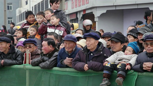 潘小姐:中国春节期间，陕西西安，一群围观者在观看传统的民间节日庆典或狂欢节视频下载