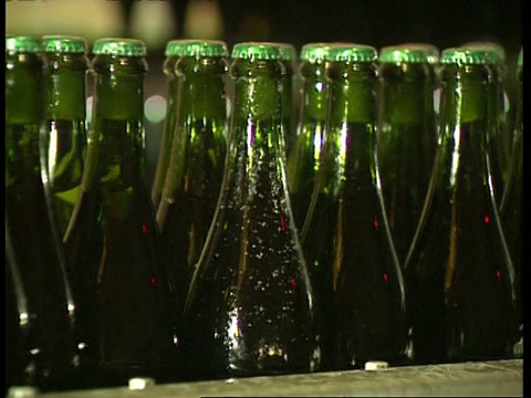 在装瓶厂，CU绿色瓶子沿着输送带移动视频素材