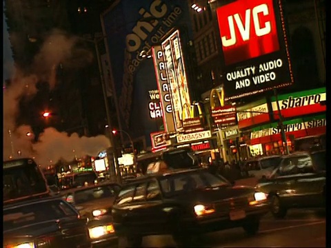 在纽约，交通驶过夜晚的城市街道，霓虹广告背景视频素材